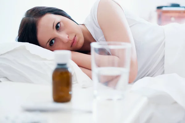 Mujer enferma sintiéndose mal y acostada en la cama — Foto de Stock