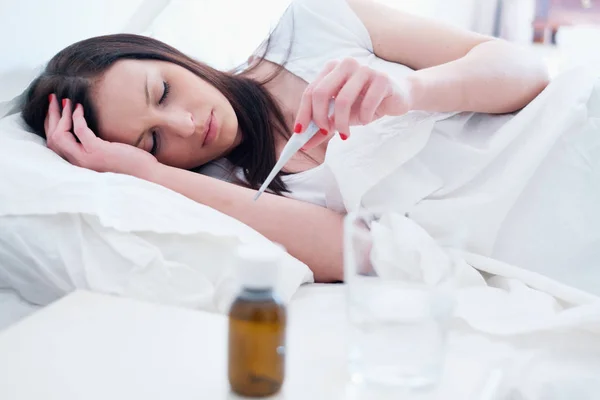 Mulher doente sentindo-se mal e deitada na cama — Fotografia de Stock