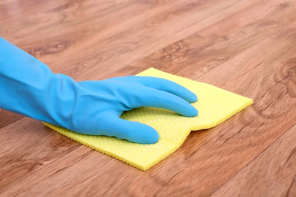 A hand cleaning a parquet floor — Stock Photo, Image