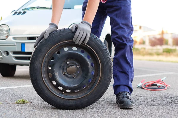 Hombre cambiando un neumático pinchado después de avería del vehículo — Foto de Stock