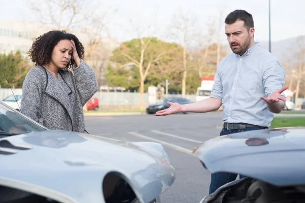 Мужчина и женщина спорят после автокатастрофы — стоковое фото