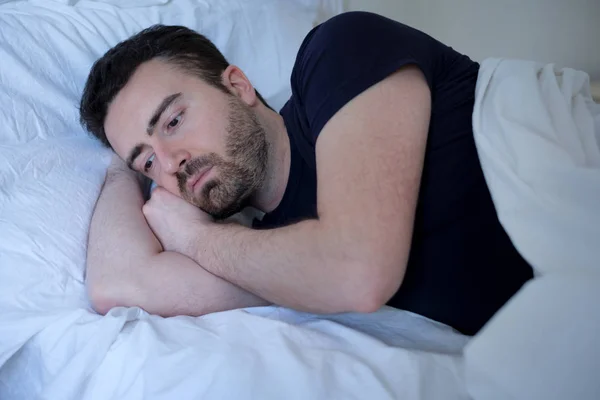 Triste y molesto hombre tratando de dormir en la cama — Foto de Stock