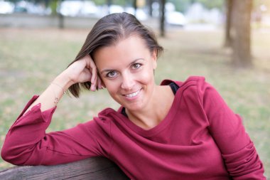 Gülümseyen ve kameraya bakarak esmer kadın