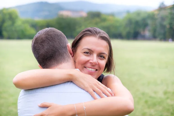 Mulher feliz abraçando seu namorado ao ar livre em um parque — Fotografia de Stock
