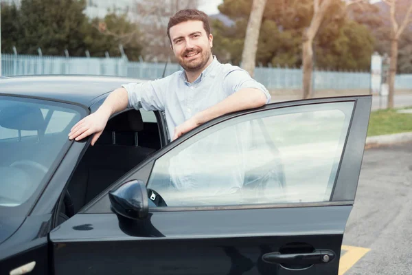 Hombre sosteniendo una llave de coche junto a su vehículo — Foto de Stock
