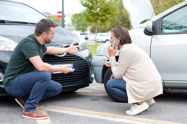 Drivrutin som kvinna och man bråkar om skador på bilen — Stockfoto