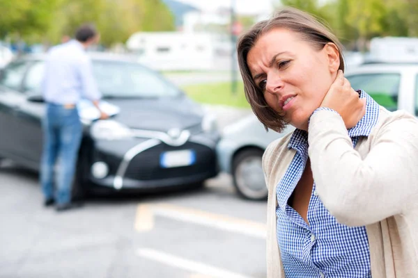 Mujer sintiendo dolor después de accidente de coche en la ciudad —  Fotos de Stock