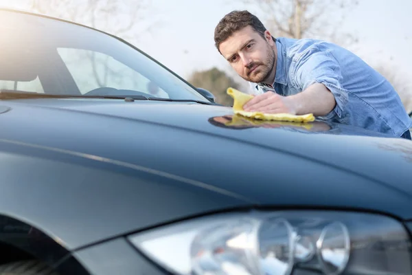 Homem cuidando e limpando seu carro — Fotografia de Stock