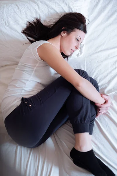 Donna triste e sola sdraiata nel suo letto — Foto Stock