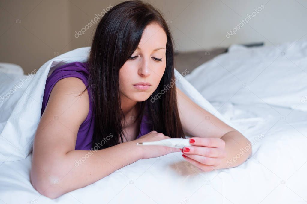 Woman feeling depressed and sad after looking at pregnancy test