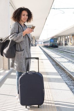 Bir tren bekleyen genç siyah kadın