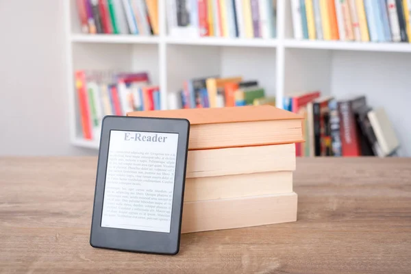 Lector de libros electrónicos en una pila de libros — Foto de Stock