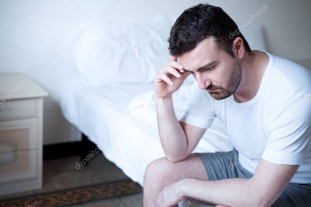 Sad and upset man waking up in the morning