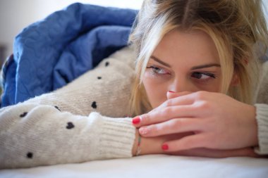 Bir yatak odası yatakta yatan yalnız hüzünlü kız