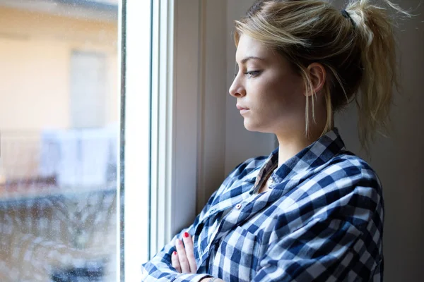 Chica preocupada y sola al lado de la luz de la ventana — Foto de Stock