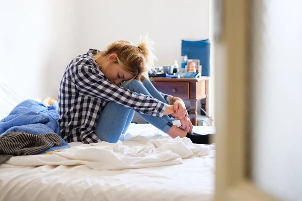 Mujer joven llorando en la cama después de la violencia doméstica en casa — Foto de Stock