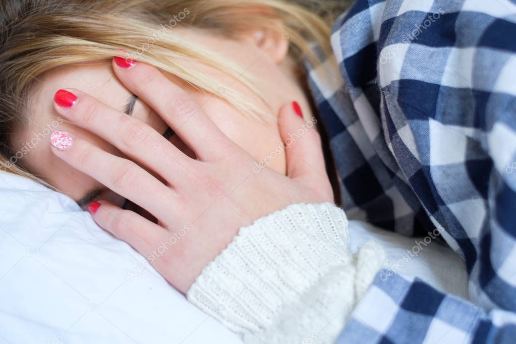  Young woman crying in bed after domestic violence at home