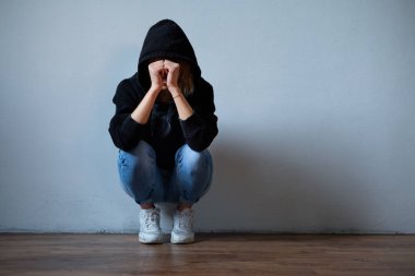 Genç kız yüzünü kapüşonlu sweatshirt b izole altında gizleme