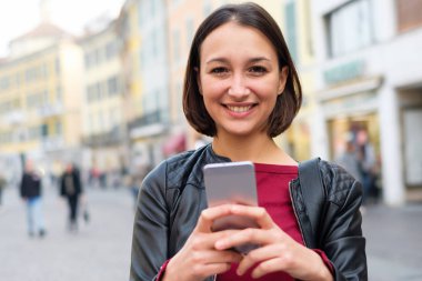 Mutlu genç öğrenci rahat telefonunuzun ve kentsel şehirde giyinmiş