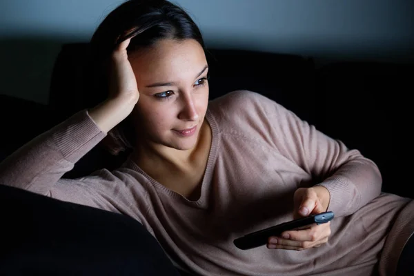 Girl with television remote watching a movie — Stock Photo, Image