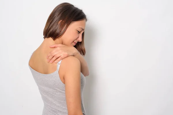 Девушка страдает от боли в шее и плече — стоковое фото