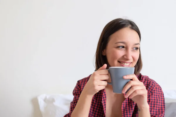 Woman relaxing and looking for coziness drinking from a cup — Stock Photo, Image