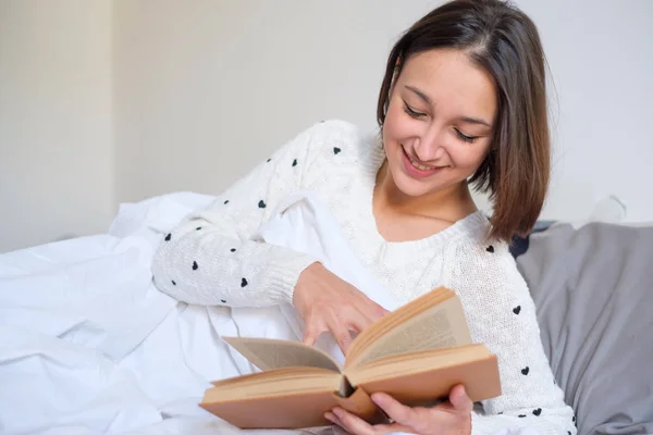 Frau liest morgens Buch im Bett — Stockfoto