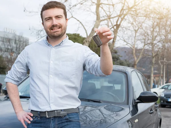 Άνθρωπος που κρατά ένα κλειδί του αυτοκινήτου δίπλα από το όχημά του — Φωτογραφία Αρχείου