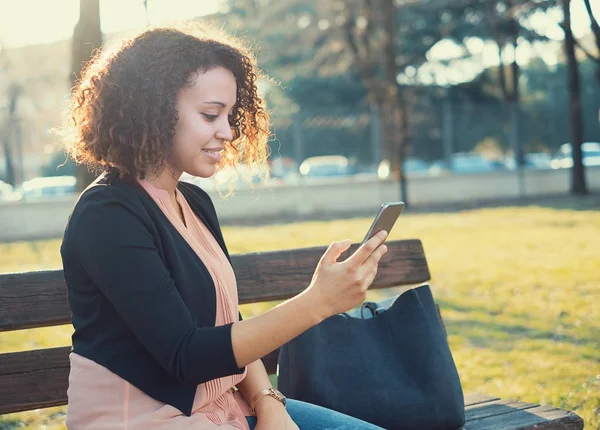 Zwarte vrouw met behulp van de app op mobiele telefoon — Stockfoto