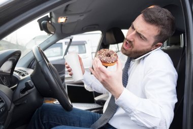 Kahvaltı ve arabada oturmuş sürüş adam
