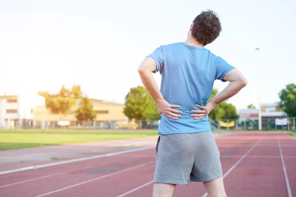 Sportsman pocit bolesti zad kvůli výhřezem ploténky Stock Obrázky