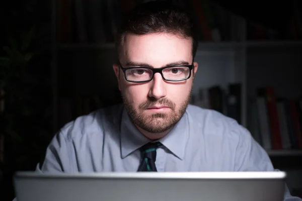 Uomo d'affari che lavora e guarda l'esposizione del computer portatile di notte — Foto Stock