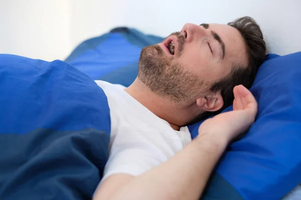 Homem na cama sofrendo por síndrome da apneia do sono — Fotografia de Stock