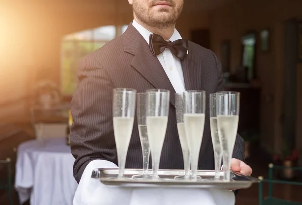 Sonriente camarero alegre con copas de champán — Foto de Stock