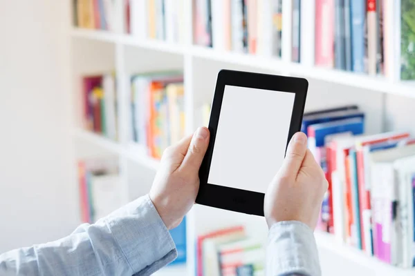 E-book reader in hands in a bookstore — Stock Photo, Image