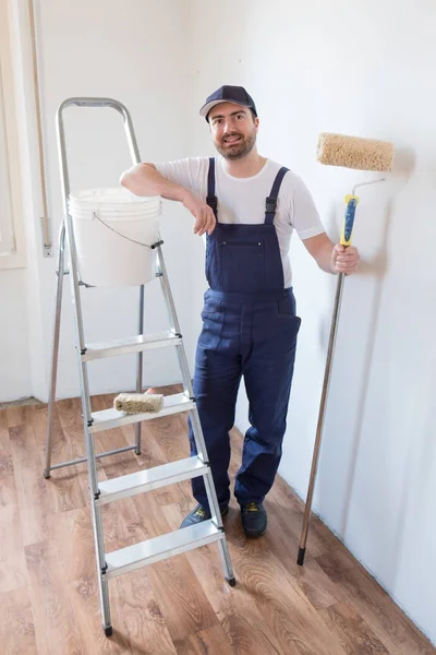 Adam boyama araçları tutarak bir duvar boyası için hazır — Stok fotoğraf