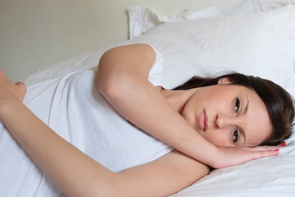 Грустная и одинокая женщина, лежащая в постели — стоковое фото