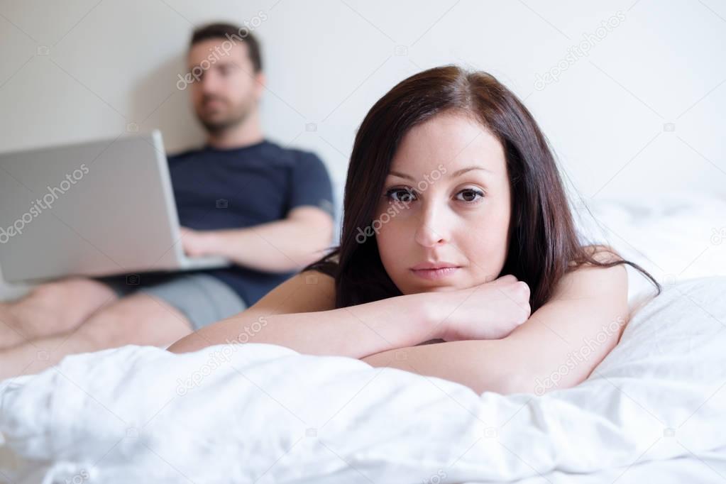 Bored woman and couple lying in the bed