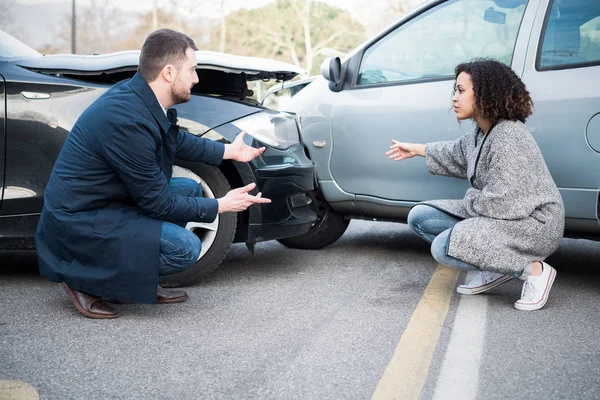 Hombre y mujer discutiendo después de un accidente de coche malo — Foto de Stock