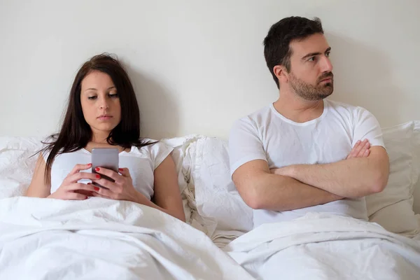 Скучная пара и обеспокоенный мужчина его жена интернет-зависимость — стоковое фото