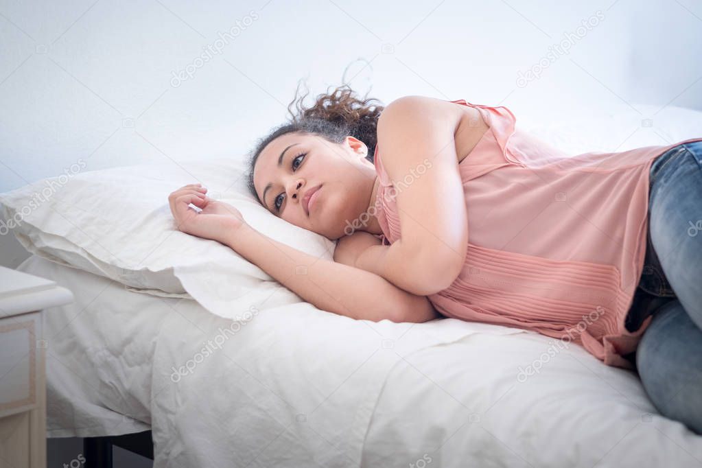 Black woman lying in her bed trying to sleep