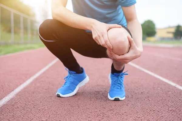 Бегущий спортсмен чувствует боль из-за травмы колена — стоковое фото