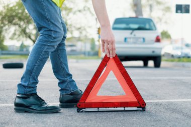 Yansıtıcı kırmızı üçgen yerleştirerek adam