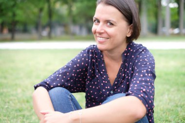 Rahat ve açık çimlerde oturan kadın