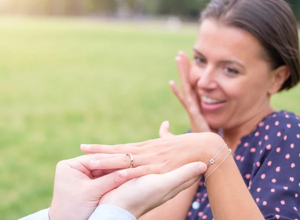 Hombre poniendo un anillo de compromiso después de la propuesta en un lugar romántico —  Fotos de Stock