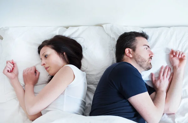 Triste y pensativa pareja después de discutir acostado en la cama —  Fotos de Stock