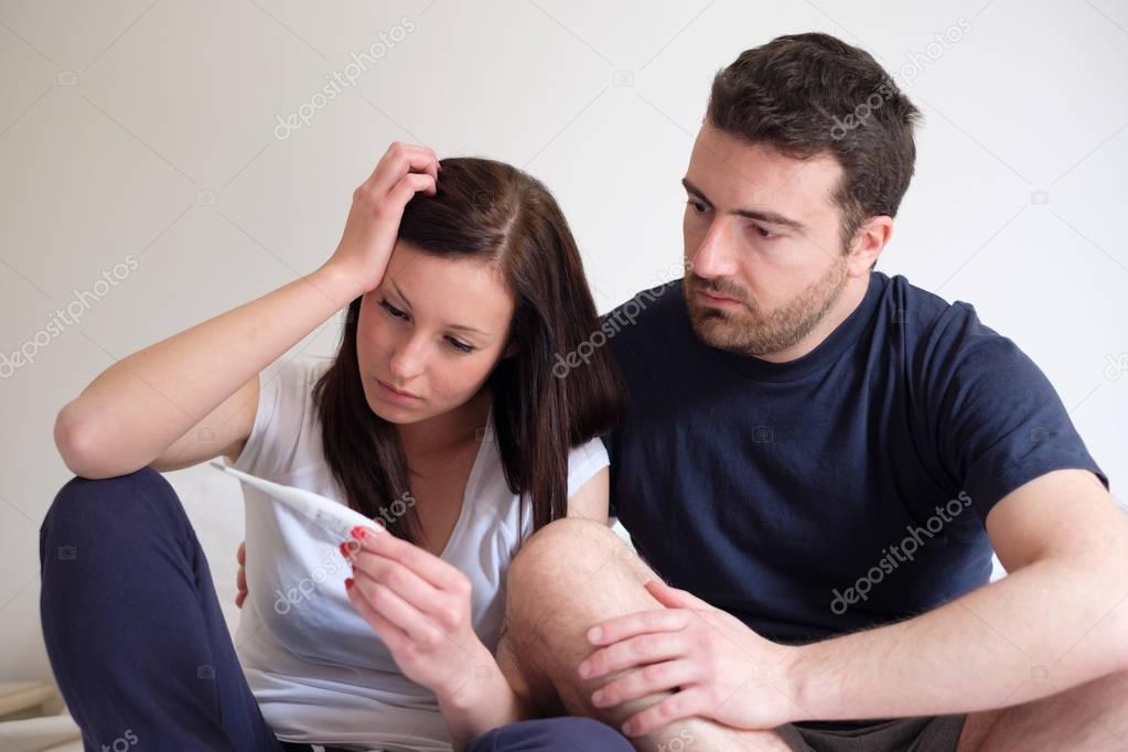 Sad lovers couple after pregnancy test result
