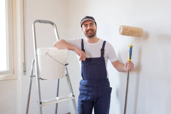Man klaar om te schilderen een muur holding tekengereedschappen — Stockfoto
