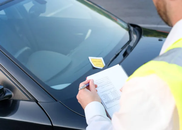 Oficial de policía que da una multa por violación de estacionamiento — Foto de Stock