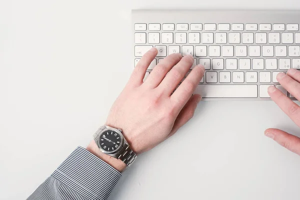 Affärsman hand arbetar på datorns tangentbord bär en klocka — Stockfoto